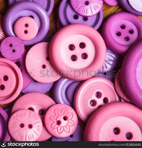 A lot of pink and purple sewing buttons closeup