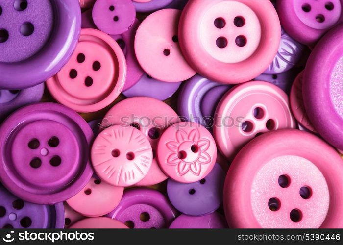 A lot of pink and purple sewing buttons closeup