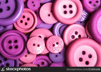 A lot of pink and purple sewing buttons closeup