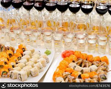 a lot of sushis and drinks on buffet table, catering