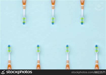 A lot of toothbrushes lie on a pastel blue background. Top view, flat lay. Minimal concept.. A lot of toothbrushes lie on a pastel blue background. Top view, flat lay. Minimal concept