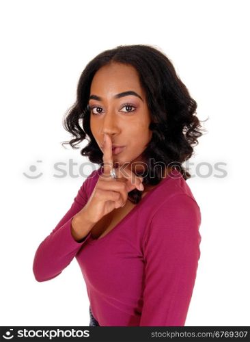 A lovely african american woman with long curly black hair holding herfinger over her mouth, don&rsquo;t talk, isolated for white background.