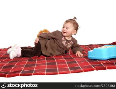 A lovely baby girl in a brown dress lying on a blanket on the floor,isolated for white background.