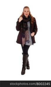 A lovely blond young woman standing in a winter jacket and boots with abig scarf, isolated for white background.