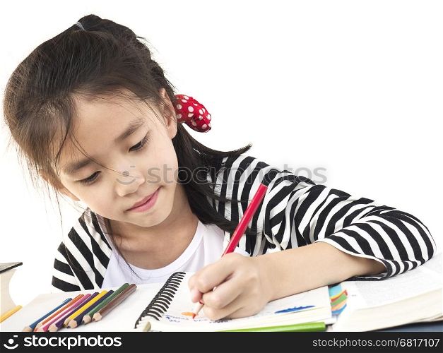 A lovely girl is doing homework, coloring or drawing a book