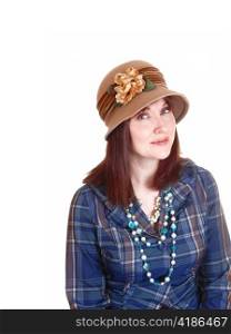A lovely lady in her forties sitting for a portrait with red hair and a brownhat in a blue checkered blouse for white background.