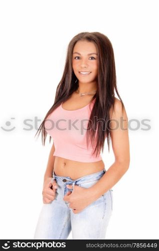 A lovely picture of a young pretty woman standing in jeans and a pinktop, smiling, isolated on white background.
