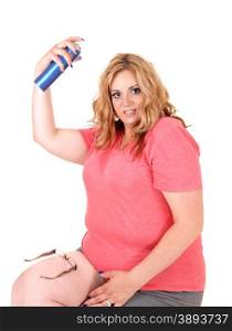 A lovely plus size woman sitting in shorts on a chair and spraying hairspray on her hair, isolated foe white background.