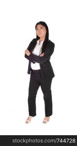 A lovely smiling Asian business woman standing with her arms crossed in a black business suit and white blouse, isolated for white background