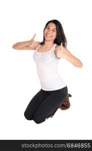 A lovely smiling Hispanic woman kneeling on the floor showing herthumps up, isolated for white background.