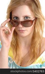 A lovely teenage girl in closeup holding her sunglasses and lookingover the frame, with blond hair and necklace, over white background.