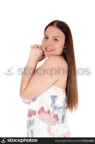 A lovely teenager girl standing in profil waist up in a pastel sommer dres swith hands folted on her face, isolated for white background
