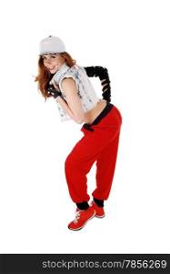 A lovely woman in red pants, jeans jacket and a hat standing in profile,isolated on white background.