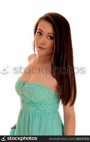 A lovely young Asian woman with long brunette hair wearing a turquoisedress, standing isolated for white background.