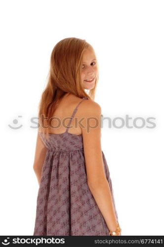 A lovely young blond girl standing isolated for white backgroundin a burgundy dress, looking over her shoulder.