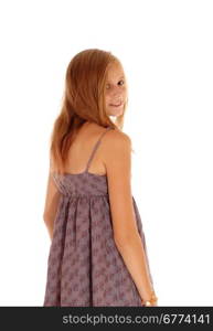 A lovely young blond girl standing isolated for white backgroundin a burgundy dress, looking over her shoulder.