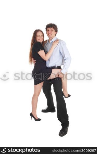 A lovely young couple, in a black dress and he in dress pants standingand dancing, her leg up, isolated for white background