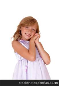 A lovely young girl in a pink dress with her hands on her face standingisolated for white background.