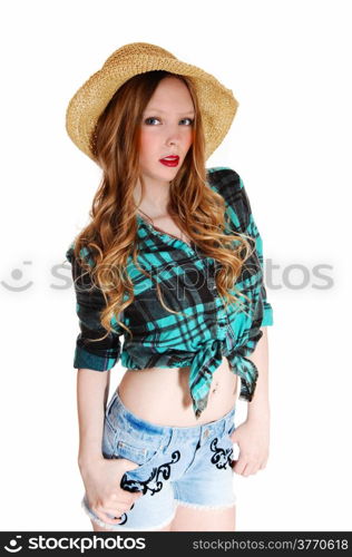 A lovely young teen girl in shorts and blouse with a straw hat standingisolated for white background.