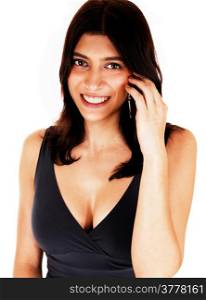 A lovely young woman in a black dress and nice figure holding a cellphone on her ear, isolated on white background.