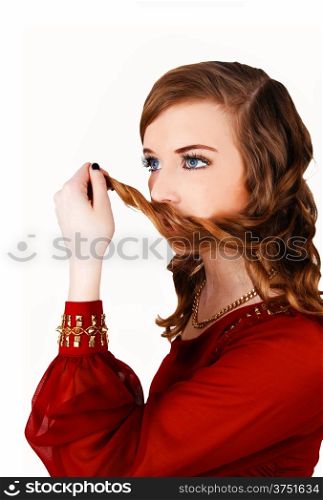 A lovely young woman in a red dress holding some hair on her mouth, standing&#xA;for white background.&#xA;