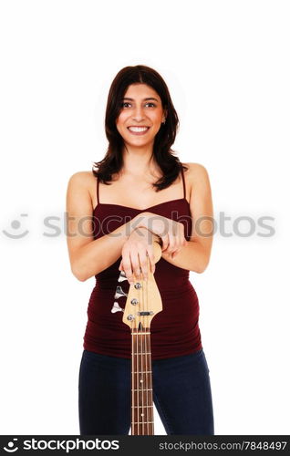 A lovely young woman standing in jeans, isolated on white background,holding her guitar and smiling.