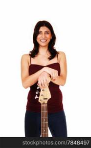 A lovely young woman standing in jeans, isolated on white background,holding her guitar and smiling.