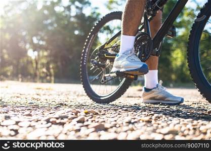 A low perspective of mountain cyclists on a rocky path at sunset Focus on shoes