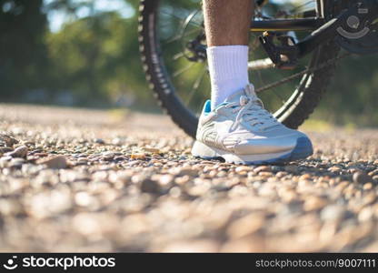 A low perspective of mountain cyclists on a rocky path at sunset Focus on shoes
