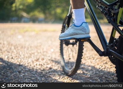 A low perspective of mountain cyclists on a rocky path at sunset Focus on shoes