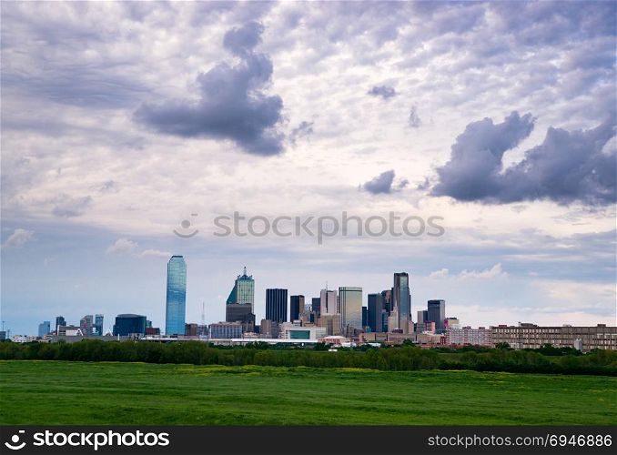 A lush green beltway appears in front of the urban landscape of Houston, TX USA