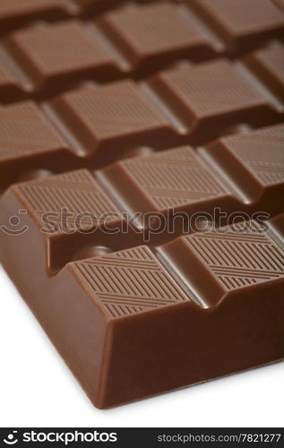 A macro photo of a large bar of milk chocolate. Shallow depth of field, focusing on the top of the first row.