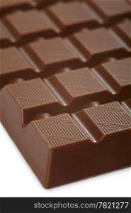 A macro photo of a large bar of milk chocolate. Shallow depth of field, focusing on the top of the first row.