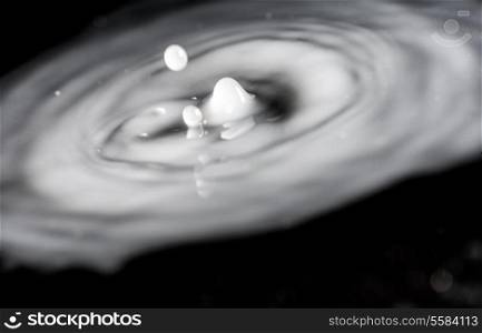 A macro shot of a milk drop collision on black