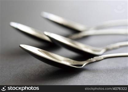 A macro shot of silver spoons on a table