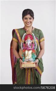 A Maharashtrian woman holding a Ganesh idol