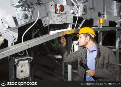 A maintenance engineer at work, tightening bolts of an industrial applience