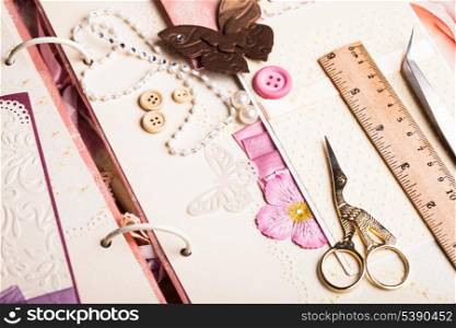 A making scrapbooking album with tolls and pink decorations