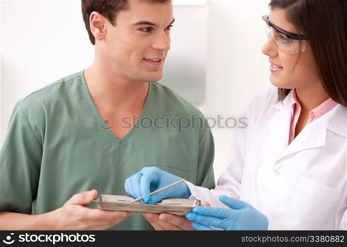 A male and female dentistry tream looking at eachother with a smile