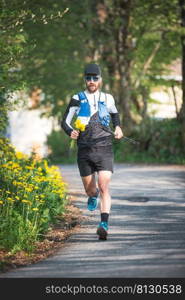 A male athlete runs on a road with yellow flowers in his hand freshly picked