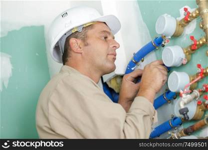 a male builder checking water meter