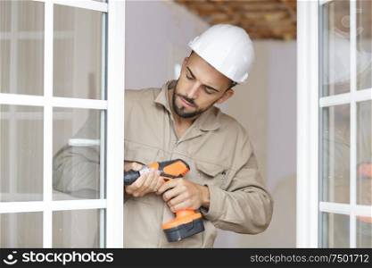 a male builder working on window
