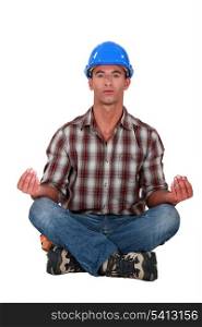 A male construction worker in a yoga position.