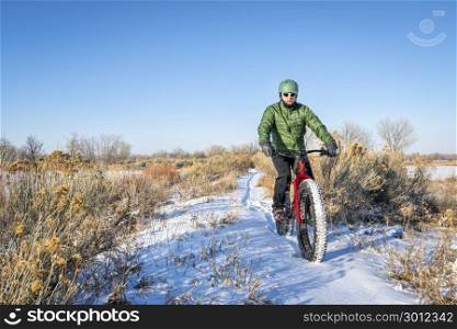 a male cyclist is riding a fat mountain bike in winter, cold day in northern Colorado