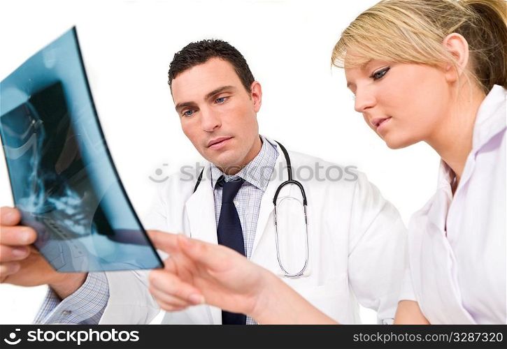 A male doctor and his female nursing colleague examining an X-ray of a human skull