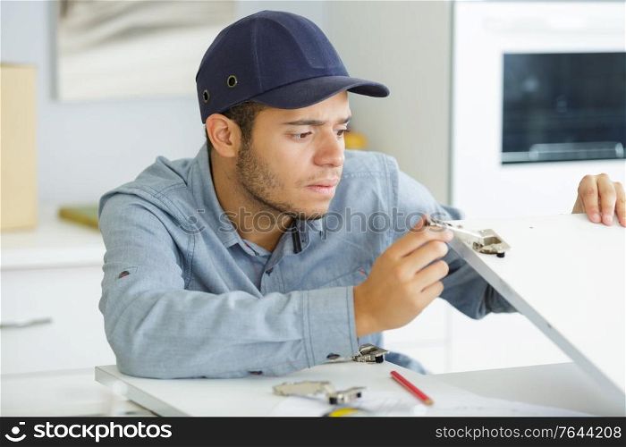 a male electrician during kitchen furniture set installation