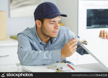 a male electrician during kitchen furniture set installation