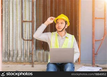 A male engineer looks at the floor plan at the construction site.
