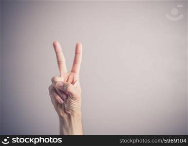 A male hand is displaying the victory sign