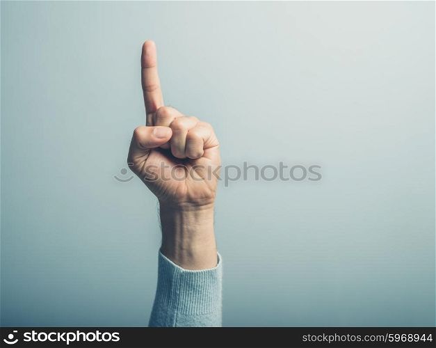 A male hand with the index finger pointing up